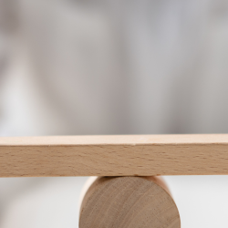 Image of male and female symbols balancing on a desk for gender pay gap header