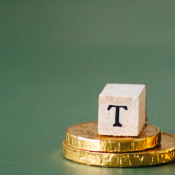 Image of Tax blocks and coins on a green background.